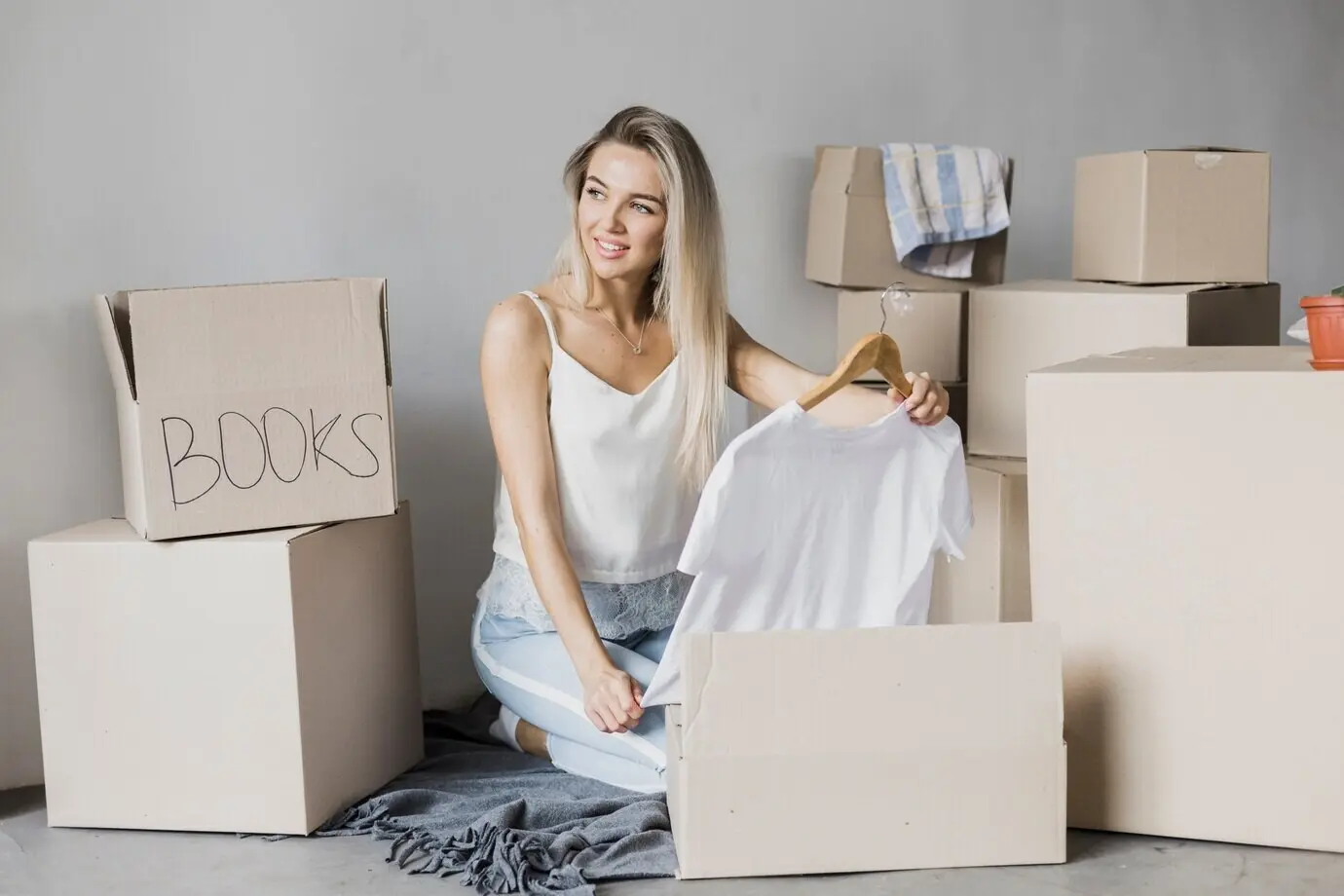 Vorderansicht einer jungen Frau, die ein T-Shirt einpackt.